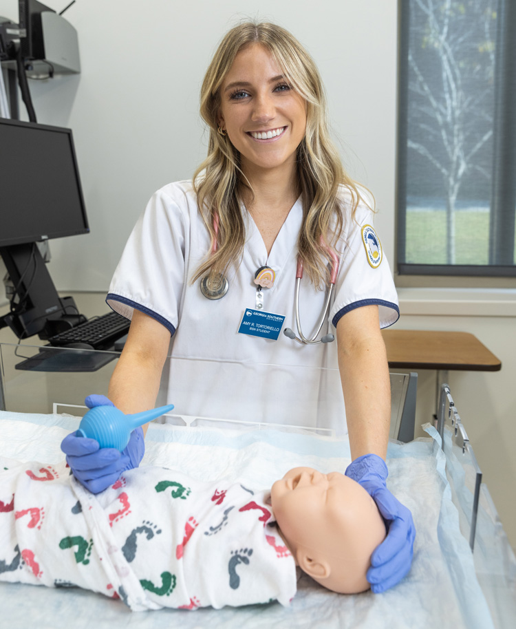 Amy Tortoriello works with a baby simulation