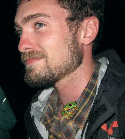 john david curlis at night with a green tree frog on his shirt collar
