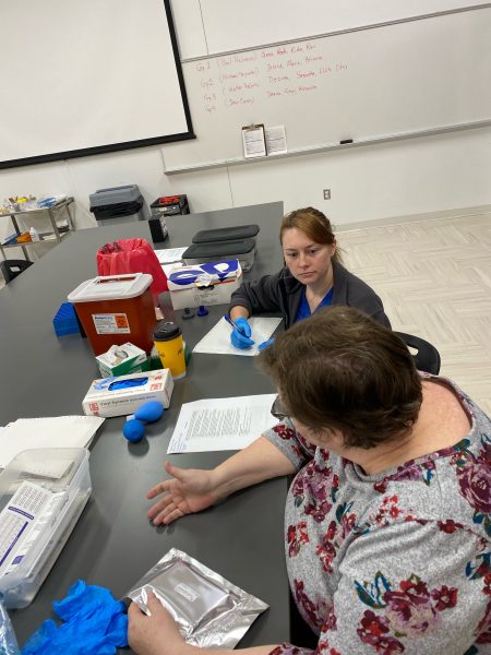 Lecturer Carol Jordan, left, and student Anna Bryan assist with a vitamin D assay as part of a study on racial disparities and cardiovascular health.