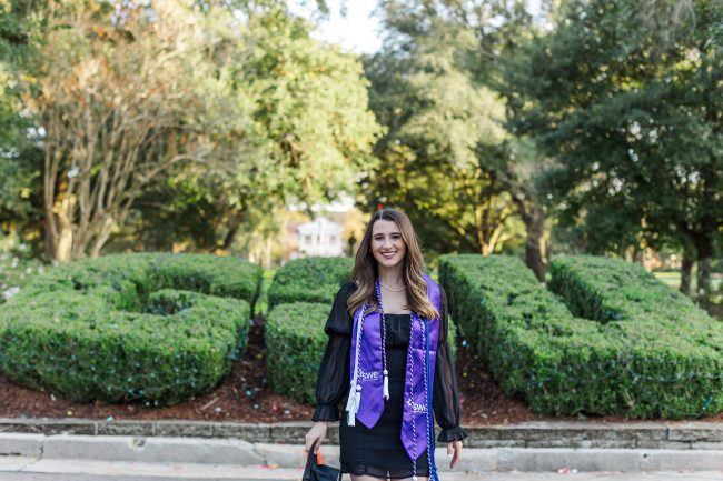 Photo of Lydia Poole in graduation attire in front of GSU bushes.
Photo Credit: Rebecka Jane Photography